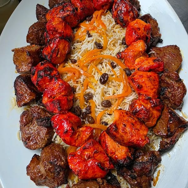 A platter of Afghan chicken and beef kabobs with rice, carrots, and raisins from Khorasan Kabab.